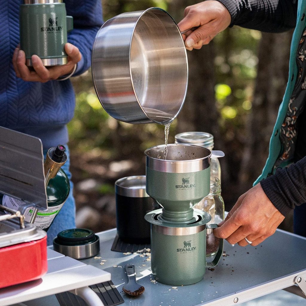 A hand holding the Stanley Pour Over Set, demonstrating its compact size and ease of use for on-the-go brewing.