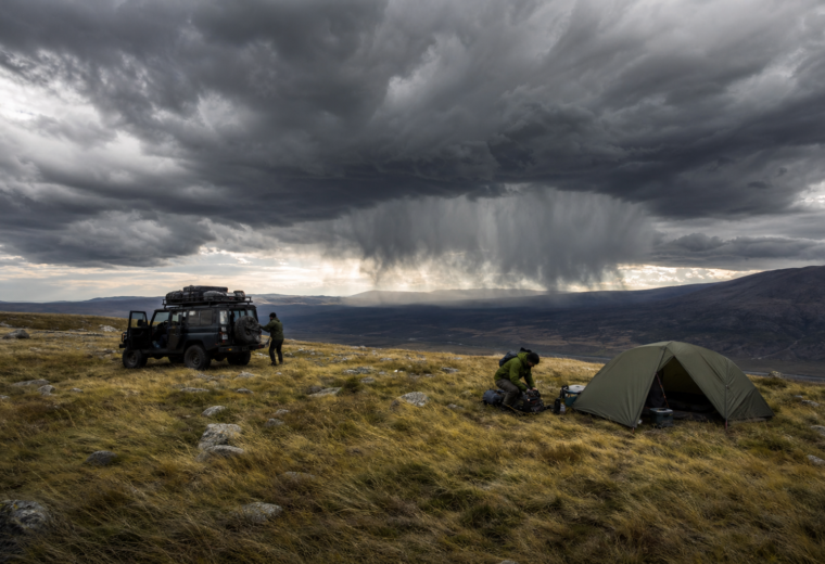 Remote campsite under building storm clouds with virga and wind, showing weather signs campers should not ignore.